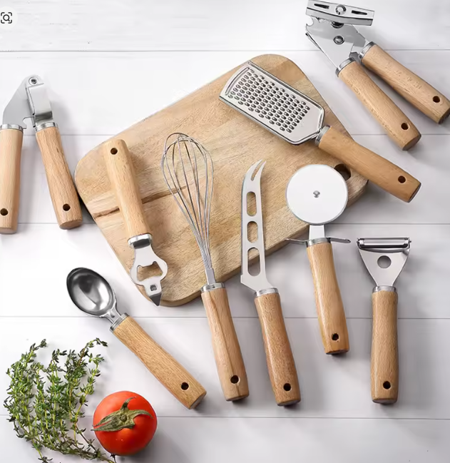 مجموعة أدوات مطبخ من الفولاذ المقاوم للصدأ بمقابض خشبية – تشمل قطاعة بيتزا، خافق بيض، سكاكين جبن وأدوات خبز متعددة الاستخدام